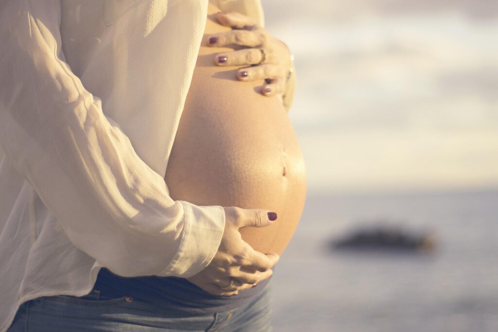 Schwangere Frau stütz ihren Bauch